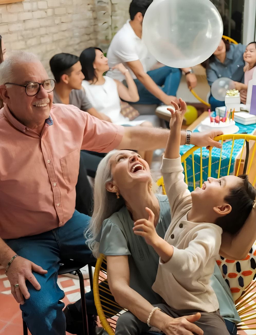 Avós e o neto reunidos em casa durante uma celebração, com adultos e crianças a partilhar momentos de convívio.