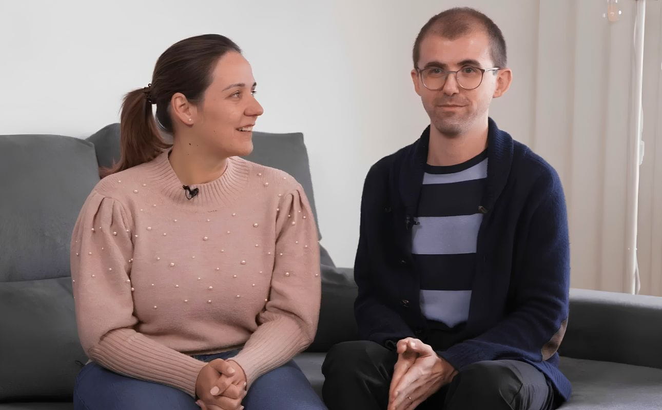 Casal sentado num sofá durante uma entrevista em ambiente doméstico, cenário associado a testemunhos reais de clientes e à experiência de compra de casa com recurso a crédito habitação.